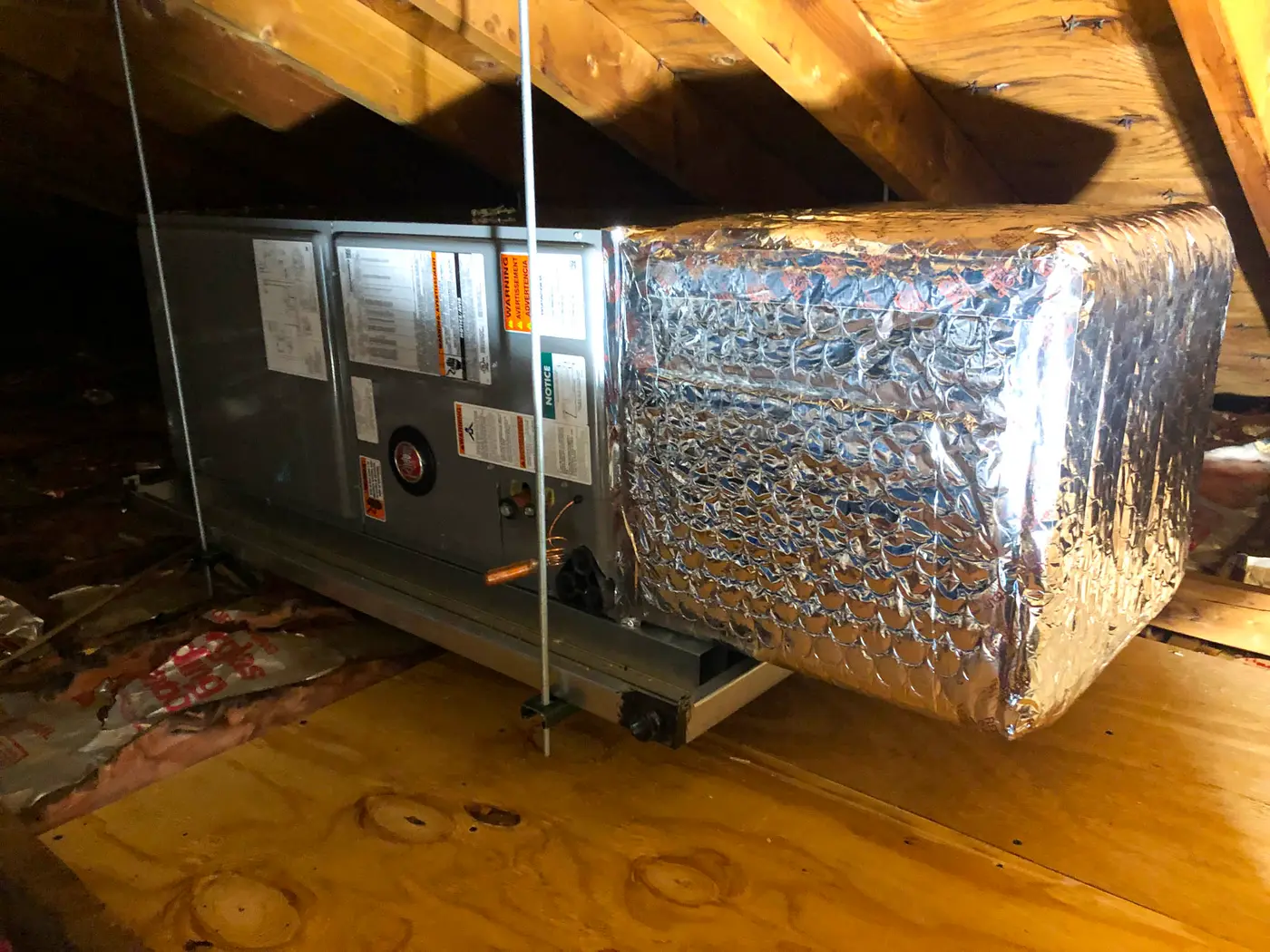 Attic air handler connected to insulated flex duct plenum on plywood