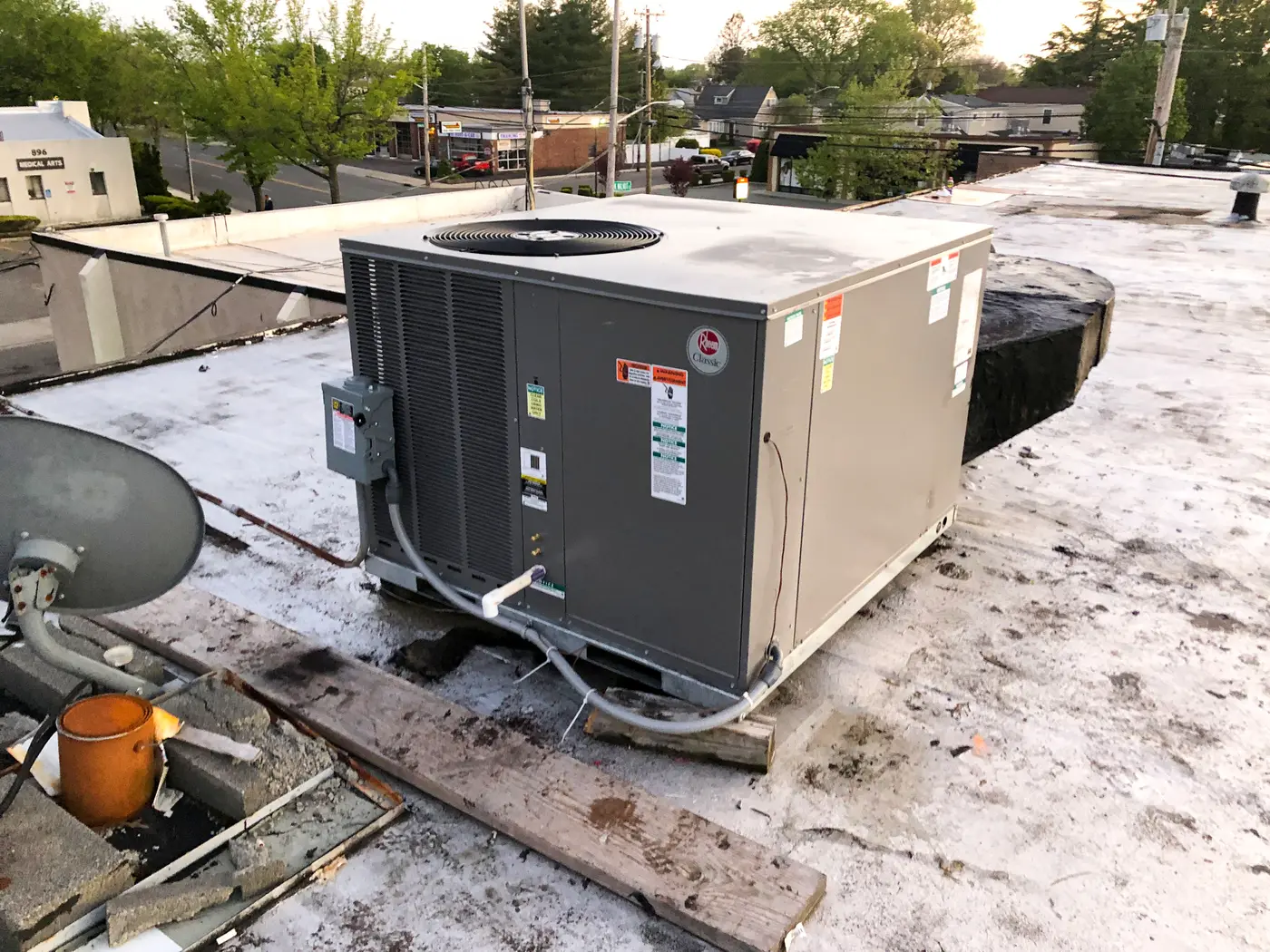 Packaged rooftop unit on curb surrounded by gravel roof debris