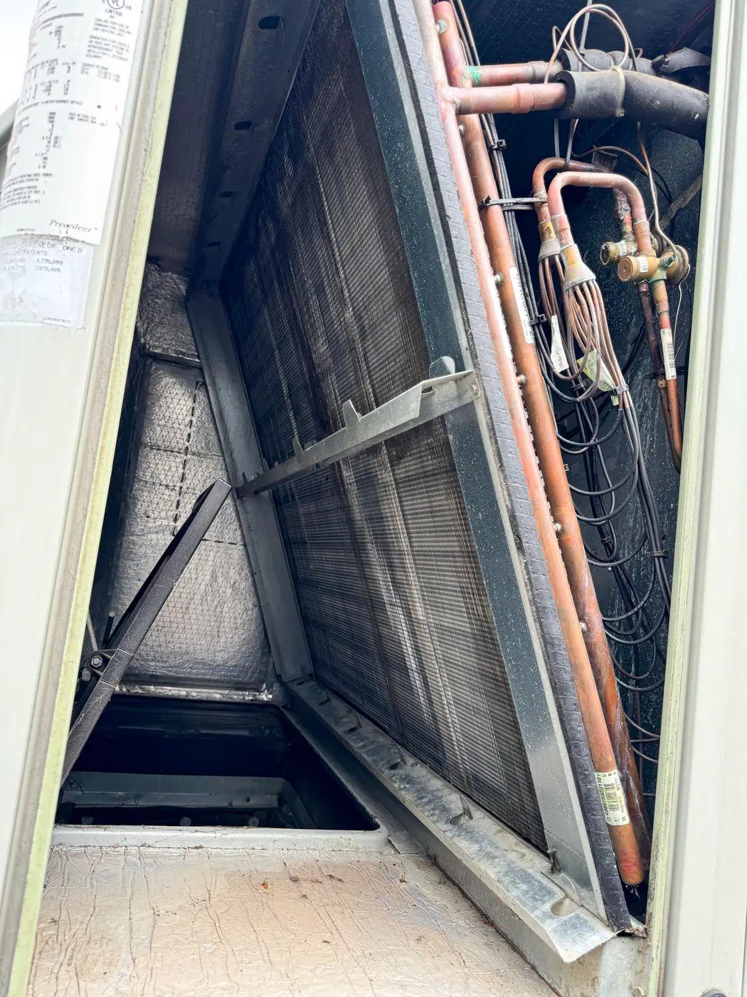 Evaporator coil and copper lines inside open air handler cabinet