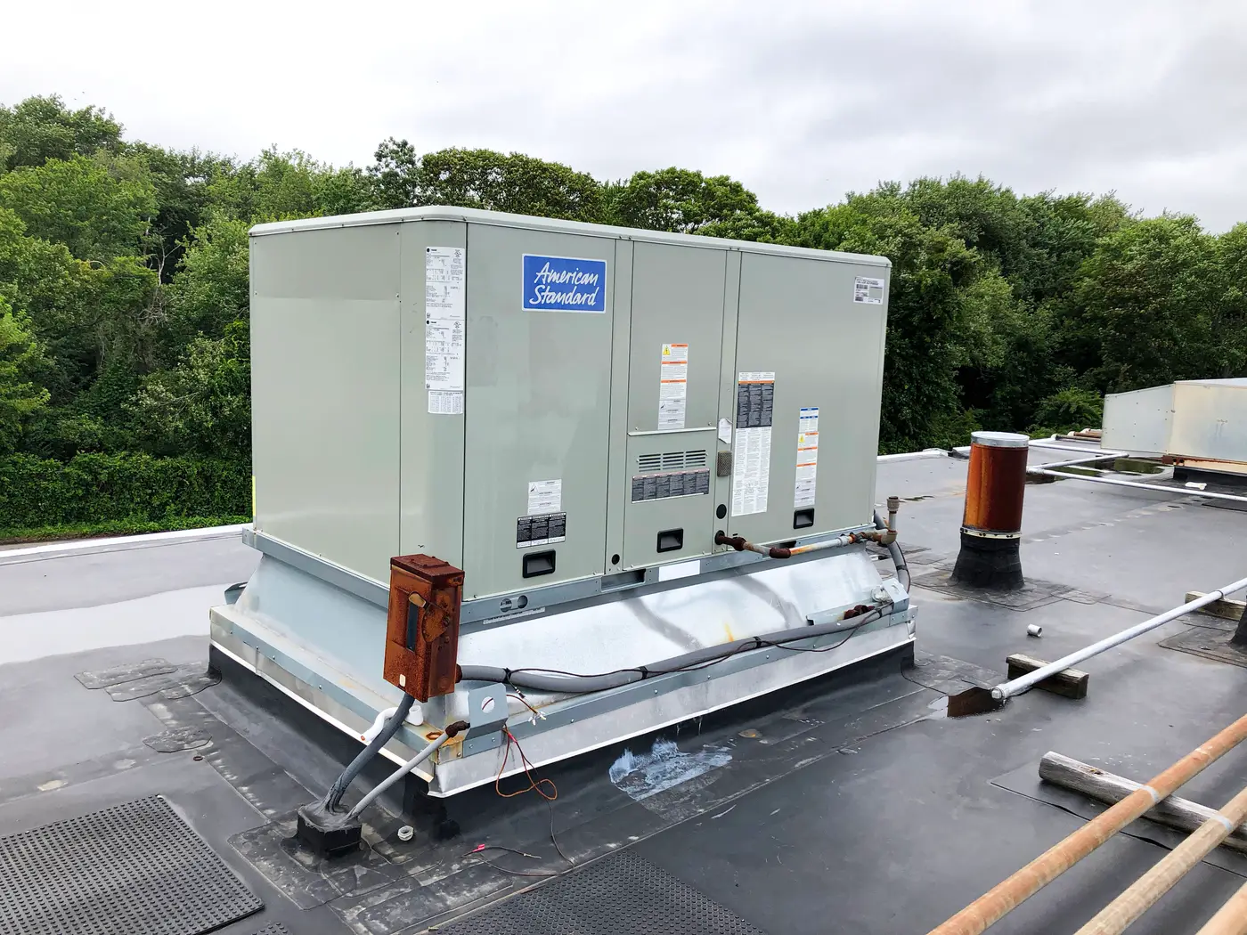 American Standard packaged rooftop unit installed on flat roof with curb