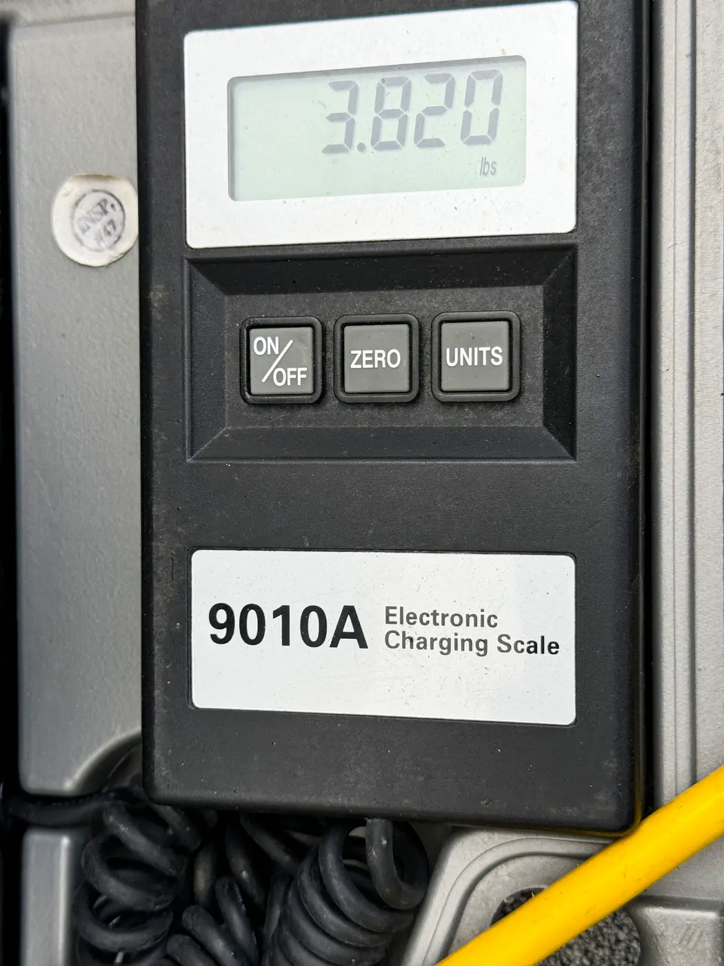 Electronic charging scale display reading 3.820 during refrigerant work