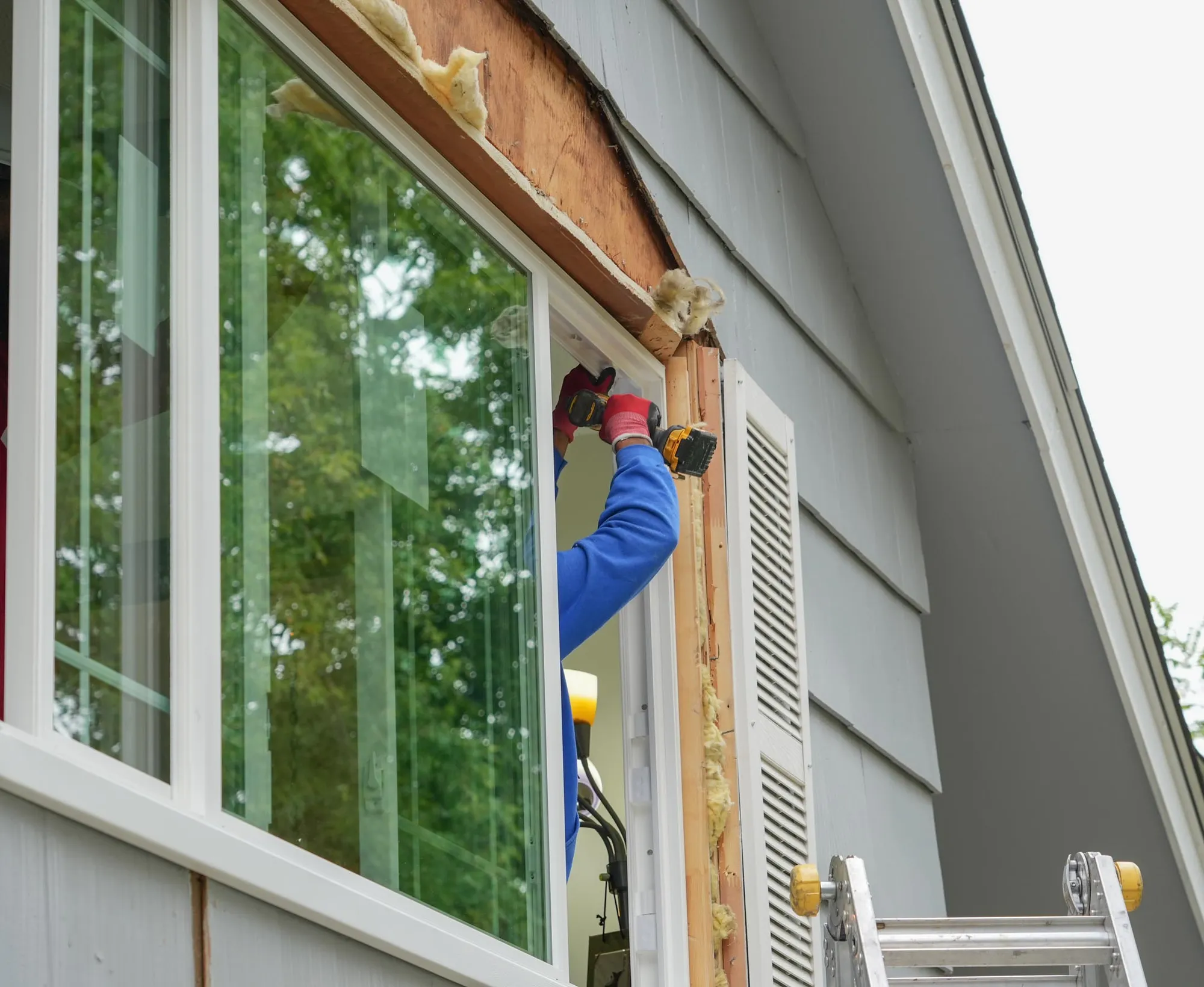 Installer securing a new window unit into a prepared opening