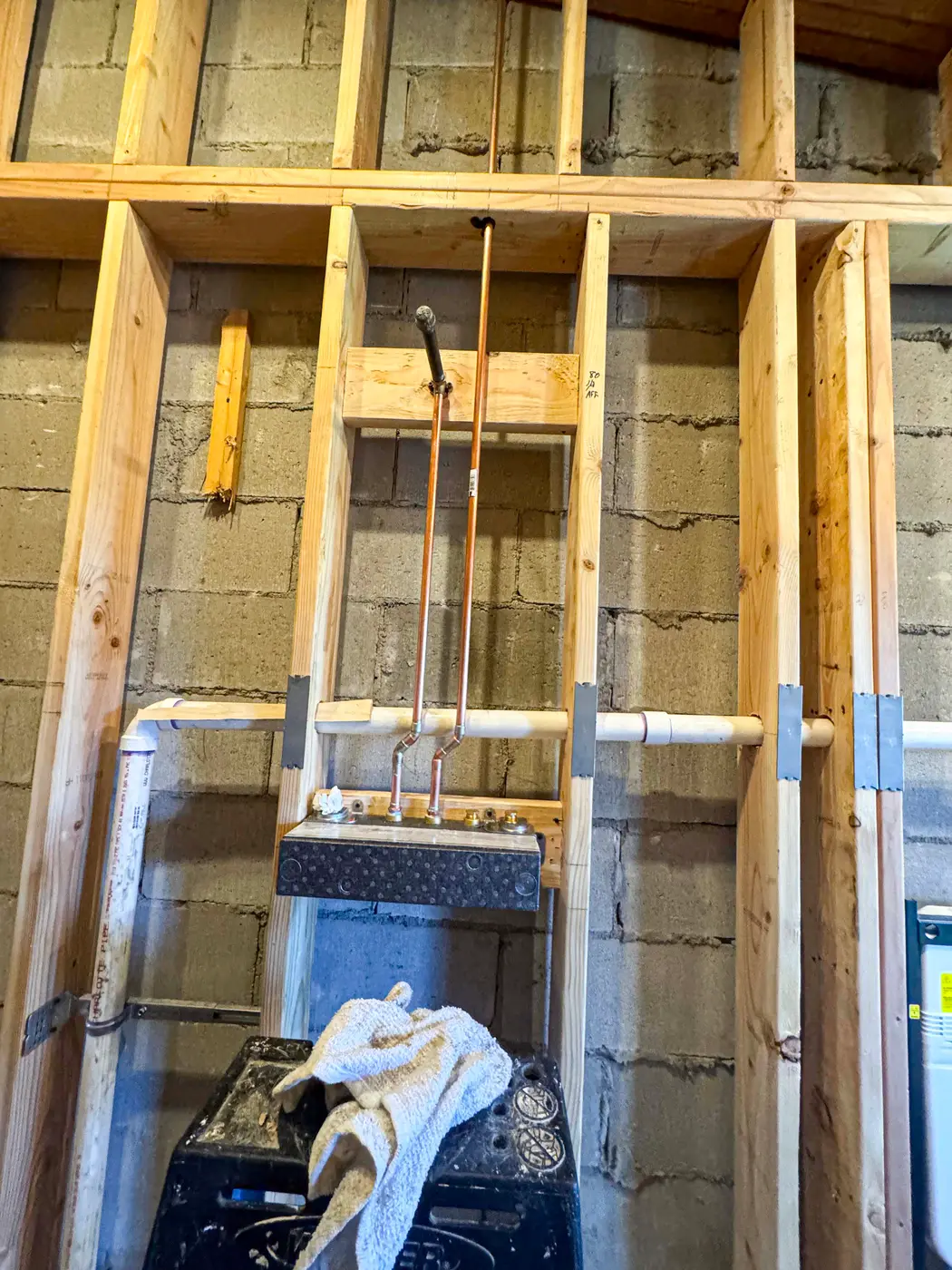 Basement bathroom rough-in with framed wall and PVC piping