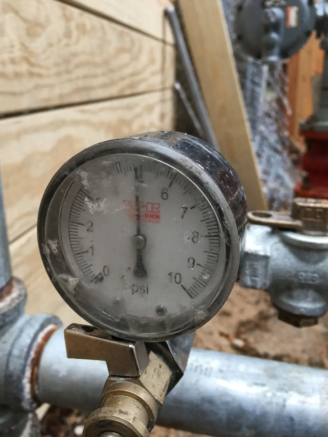 Pressure gauge mounted on galvanized pipe with a valve