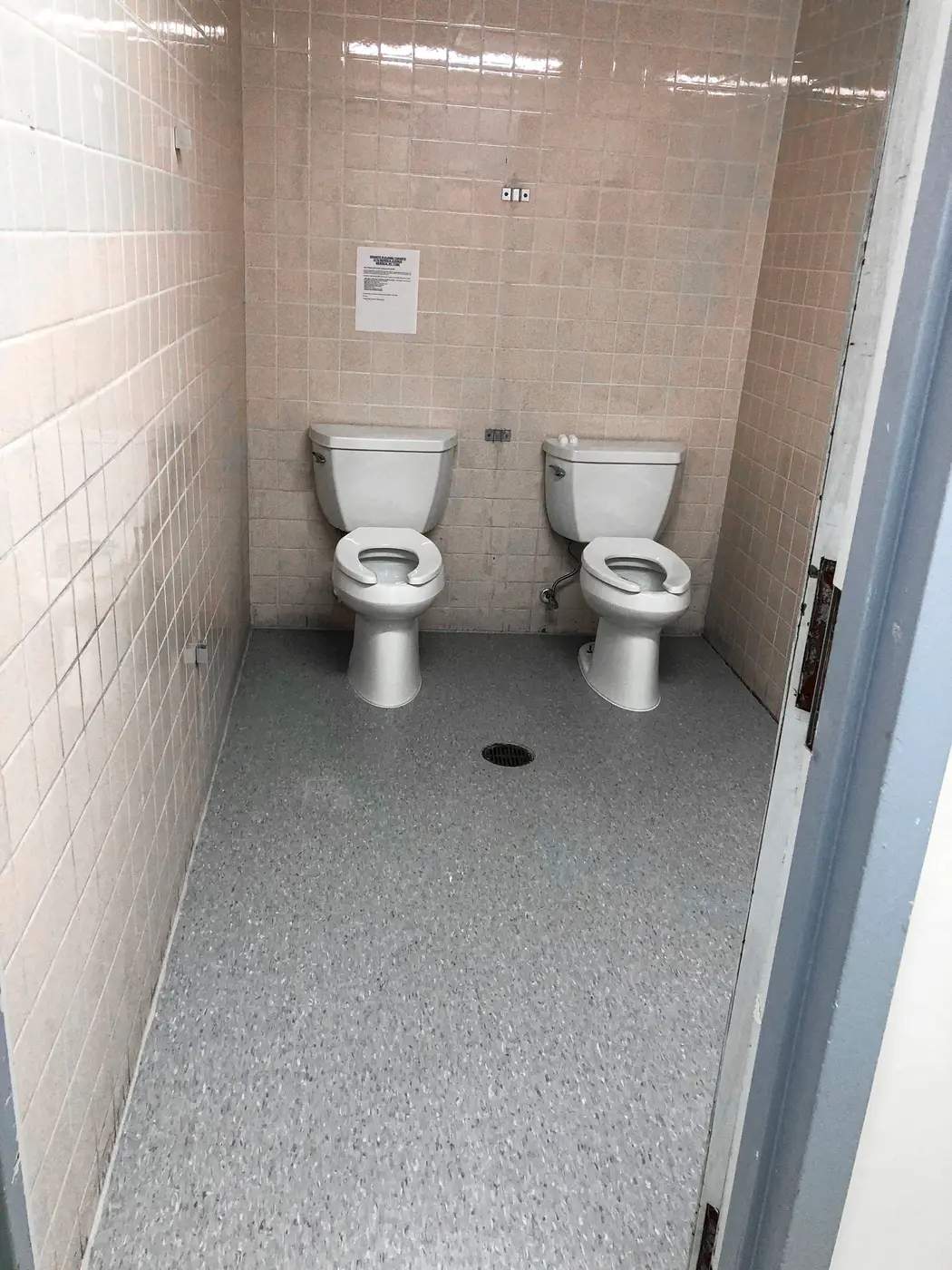 Commercial restroom with two toilets and tiled block walls