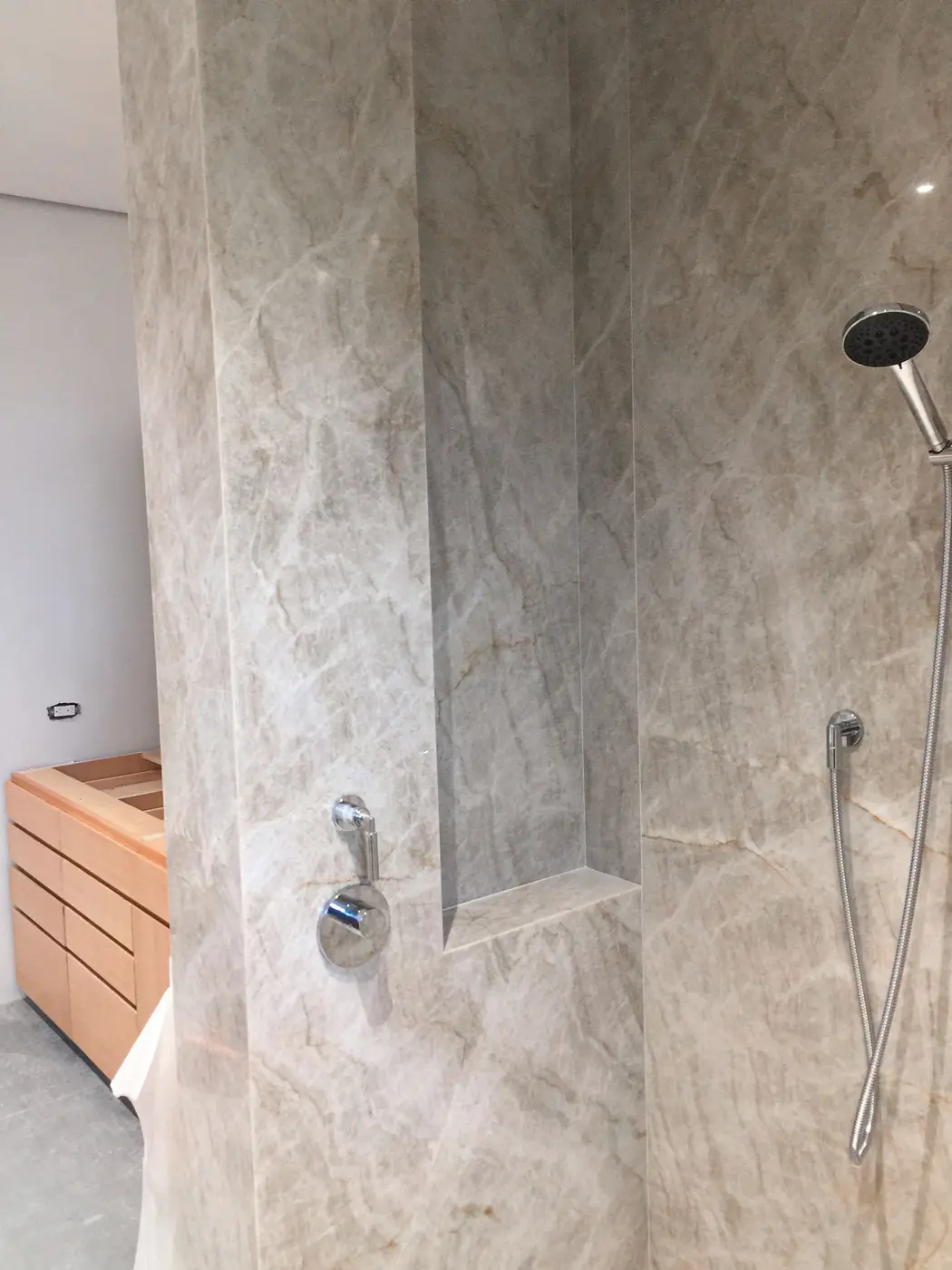 Finished marble-look shower with bench and ceiling rain head