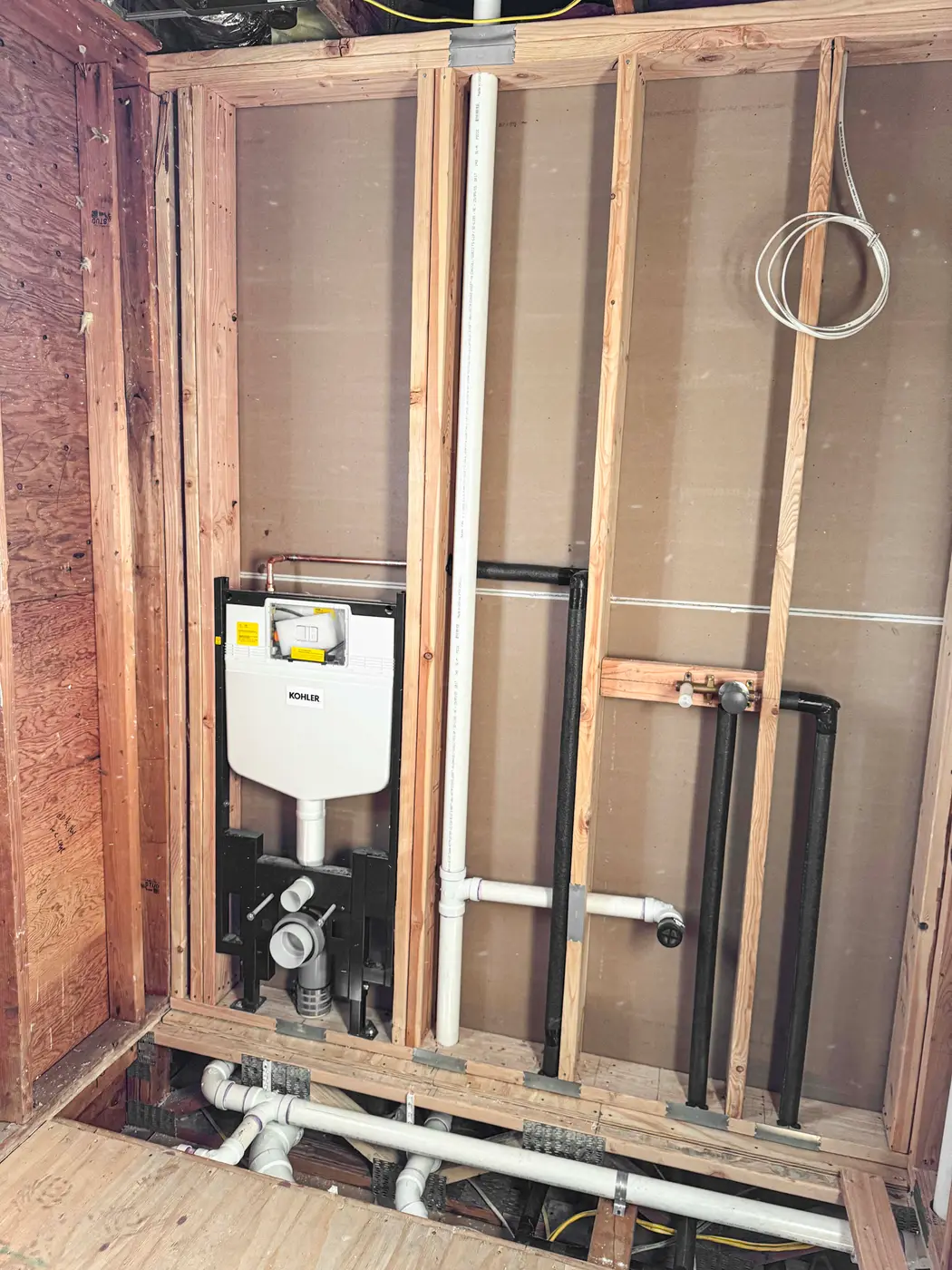 Concealed toilet carrier and tank installed in a framed wall