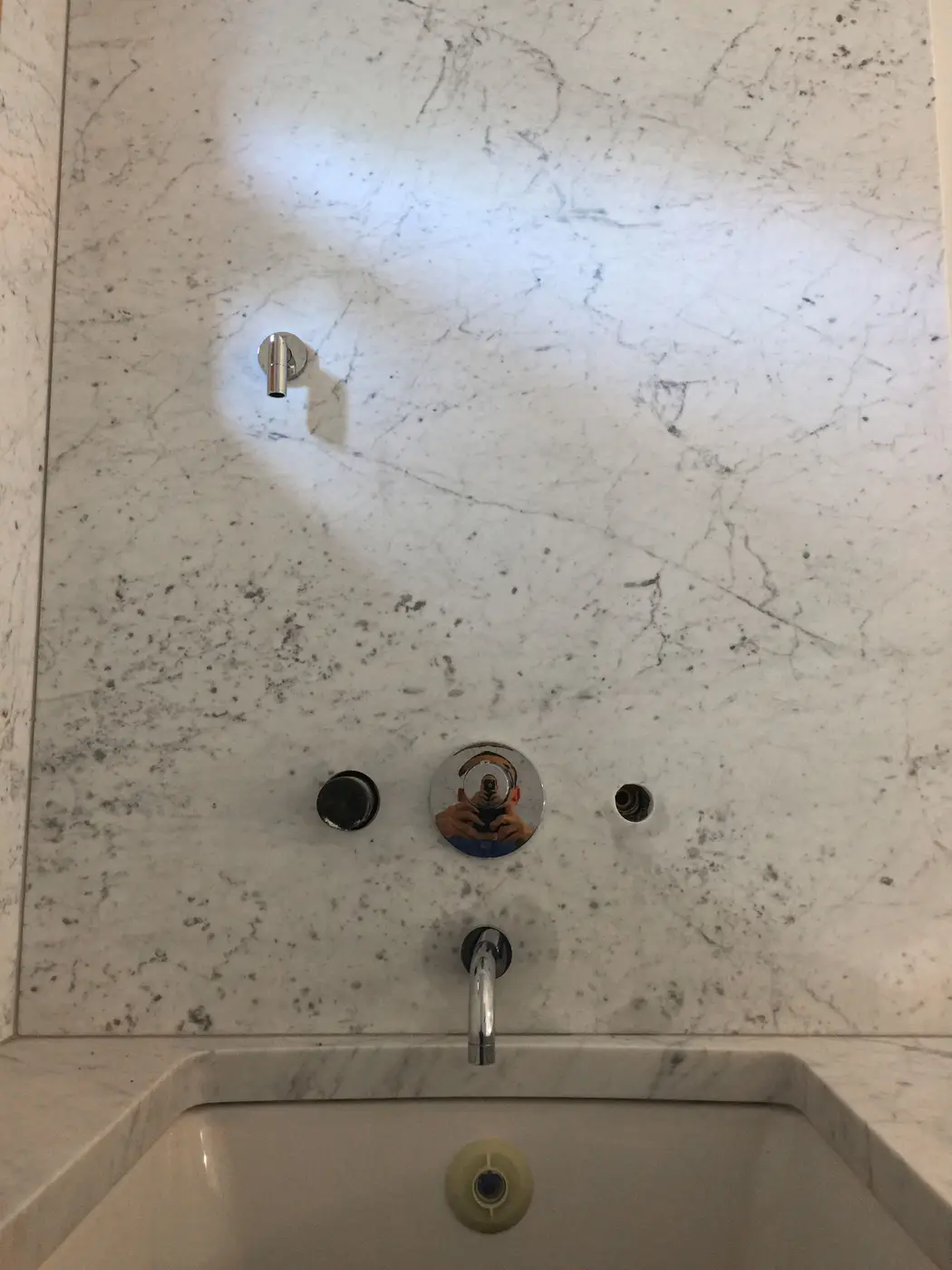 Marble tiled tub surround with chrome spout and single handle valve trim